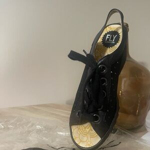 Black leather lace-up Fly London sandal.